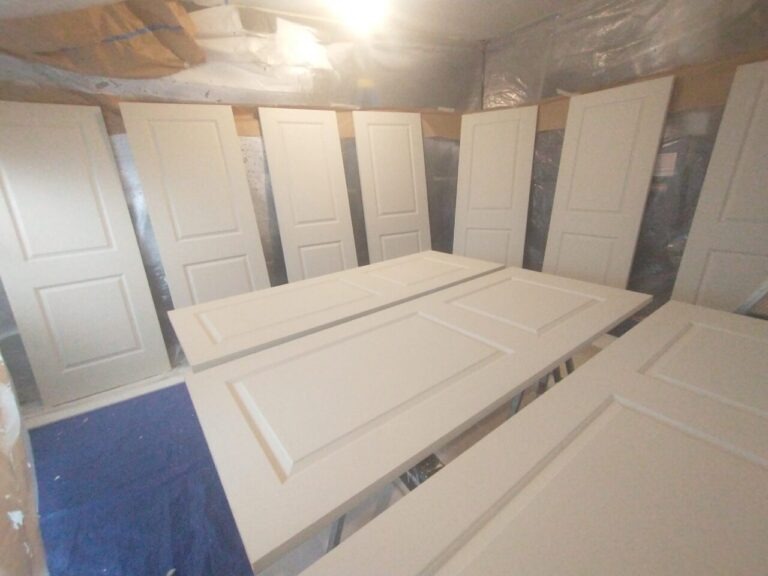 Spraying paint on new 2-panel interior doors